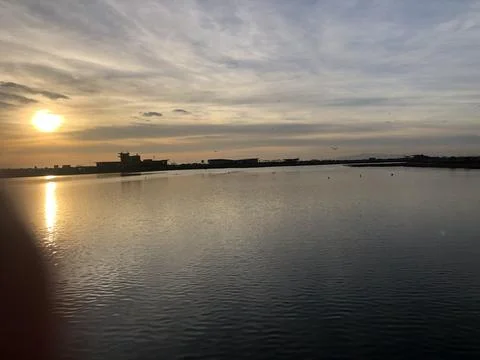 Sunset Reflection Over Calm Waters Near the Shore Stock Photos