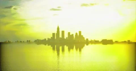 Sunset reflection over city skyline illuminating the water surface Ilustración de archivo