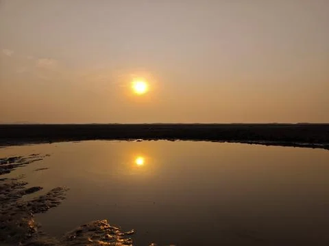 Sunset with reflection on the pond in winter day Stock Photos