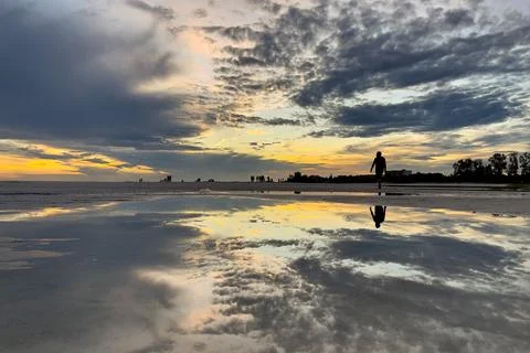 Sunset Reflection on Siesta Key Beach Florida with Silhouetted Walker Stock Photos