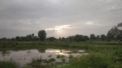 Sunset reflection in small pond with blue sky in monsoon Stock Photos