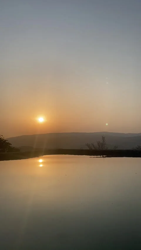 Sunset reflection on water with distant hill and clear summer sky 🌅💧 動画素材 310965097