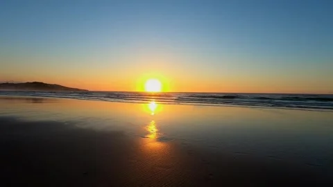 Sunset reflection on wet sand beach in Cantabria Spain Stock Footage 343226823
