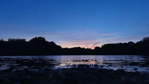Sunset Reflections Across Calm Lake Under Blue And Pink Evening Sky Stock Footage 341832836