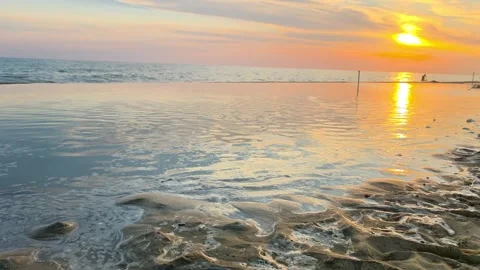 Sunset Reflections on Calm Sea with Sandy Beach at Low Tide Stock Footage 341380721