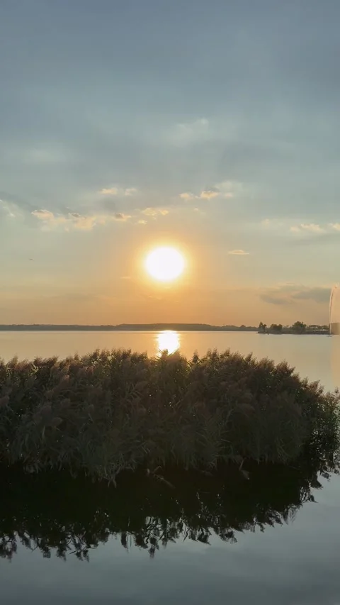 Sunset Reflections Over Lacul Morii with Bird Habitat and Distant Bucharest Stock Footage 346380114