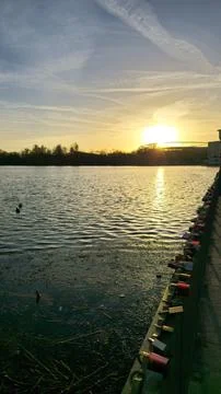 Sunset Reflections Over Tranquil Water Surrounded by Love Locks Between Couples Stock Photos