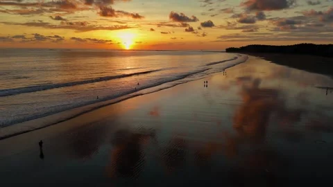 Sunset reflections on wet sand and ocean in Uvita, Costa Rica Stock Footage 328130677