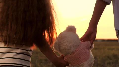 Sunset reflects on faces, Silhouette edges glow, A child enjoys the walk, The Stock Footage 317710301