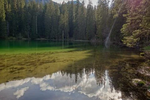 Sunset reflects over green surface of Zminje lake in Durmitor National Park.. Stock Photos