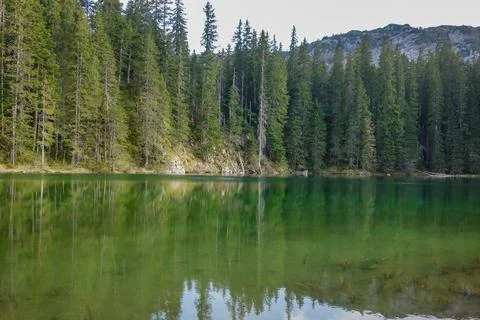 Sunset reflects over green surface of Zminje lake in Durmitor National Park Stock Photos