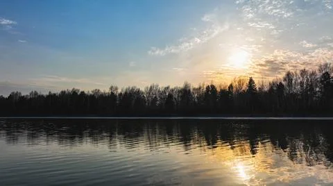 Sunset on the river against the background of the forest Stock Photos