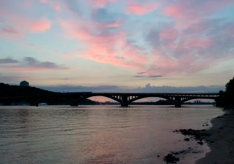 Sunset by the river against the bridge Stock Photos