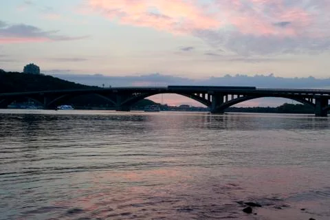 Sunset by the river against the bridge Stock Photos