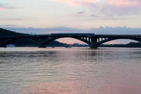 Sunset by the river against the bridge Stock Photos
