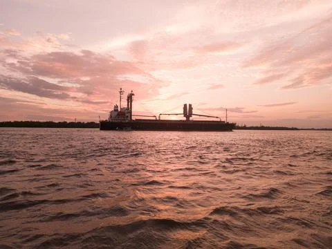 Sunset in the river and container ship Stock Photos