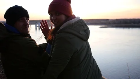 Sunset, river, autumn, two, salutation, hand, smile, camera, sitting, high. slow Stock Footage 82016557