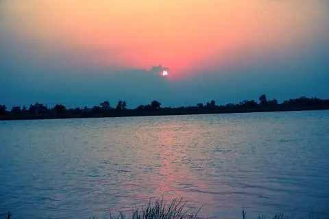 Sunset on river bank Stock Photos