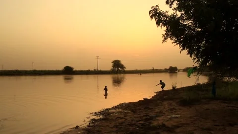 Sunset by the river with children playing Stock Footage 201164145
