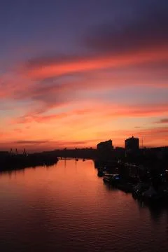 Sunset on the river in the city, rays of the sun, golden hour, water and ships Stock Photos