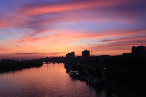 Sunset on the river in the city, rays of the sun, golden hour, water and ships Stock Photos