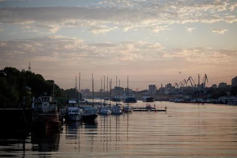 Sunset on the river in the city, rays of the sun, golden hour, water and ships Stock Photos
