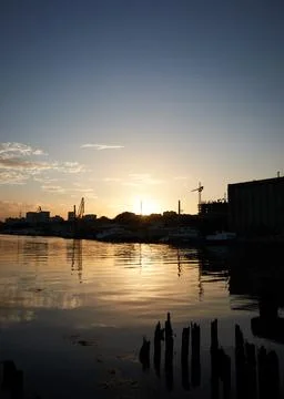 Sunset on the river in the city, rays of the sun, golden hour, water and ships Stock Photos