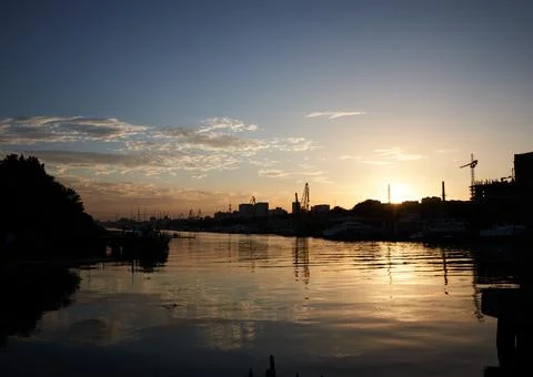 Sunset on the river in the city, rays of the sun, golden hour, water and ships Stock Photos