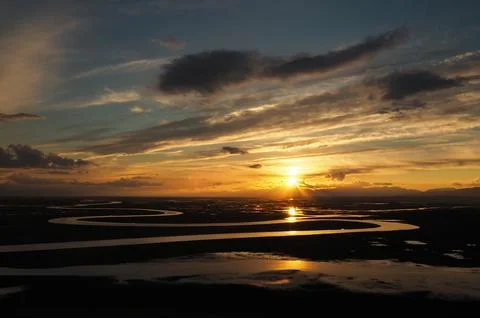 Sunset River Delta Landscape with Dramatic Golden Sky Stock Photos