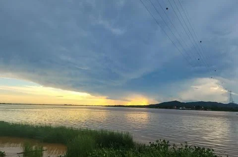 Sunset on the river with a storm on the coast Stock Photos