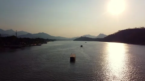 Sunset river with traditional boat and mountains in the background 스톡 동영상 344447737