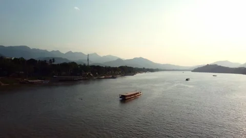 Sunset river with traditional boat and mountains in the background Video stock 344448264