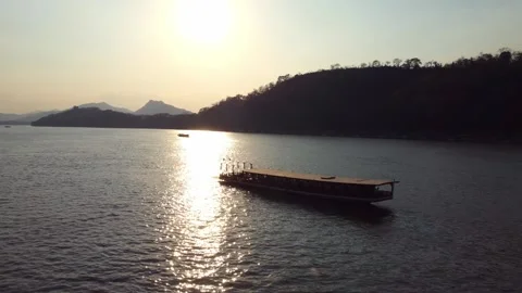 Sunset river with traditional boat and mountains in the background 스톡 동영상 344448628
