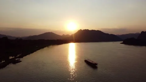 Sunset river with traditional boat and mountains in the background Video stock 344450101