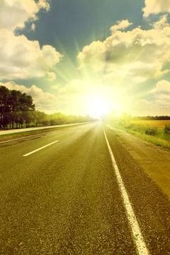 Sunset Road across fields Stock Photos