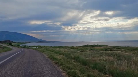 Sunset on the road overlooking the ocean and mountains Stock Footage 317386422
