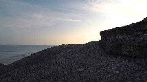 Sunset by the rocks by the sea Stock Footage 167584579