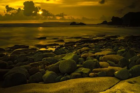 Sunset at the rocky beach in Papuma, Jember, East Java, Indonesia Stock Photos