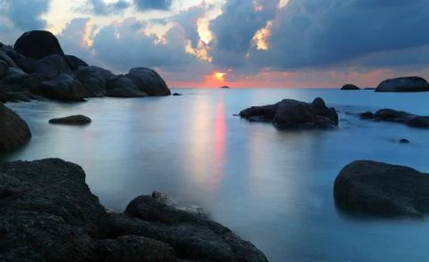 Sunset in rocky beach Stock Photos
