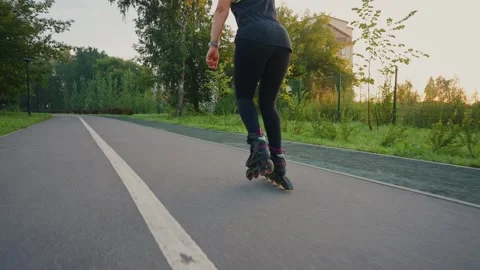 A sunset roller skating session along a serene park path in autumn Stock Footage 285152066
