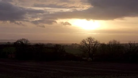 Sunset with rolling cloud in the sky, silhoutted trees &amp; hills timelapse Stock Footage 262896375