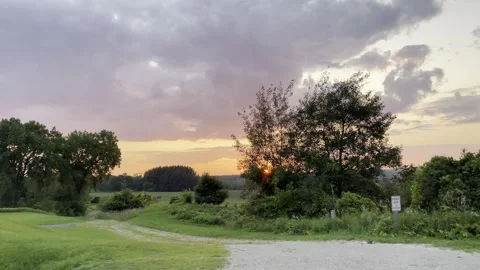 Sunset Rolling Field Trees Clouds 4K HDR Stock Footage 250370842