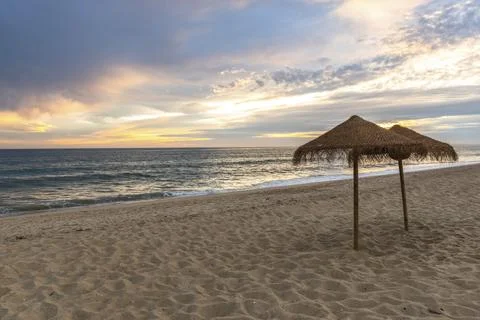 Sunset on sandy beach with ocean waves and colorful sky and clouds, Algarve, Stock Photos