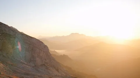 Sunset scene facing wide mountain view in spring bright golden shot panning Stock Footage 87695456