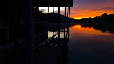 Sunset scene of lake from boat dock moving forward Stock Footage