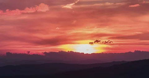 Sunset scene with sun fall behind the clouds and mountains in background Stock Footage 91015550
