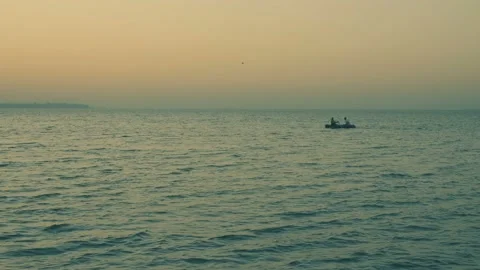 Sunset on the sea beach 4K. FULL HD, 3840x2160. Two men in a boat Stock Footage 90936463