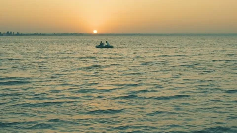 Sunset on the sea beach 4K. FULL HD, 3840x2160. Two men in a boat Stock Footage 90938664