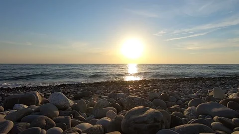 Sunset at the sea. Beautiful sky with clouds. Stone beach. Beautiful sea waves Stock Footage 150679529