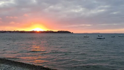 Sunset by the sea with boats floating in the background Stock Footage 161325474